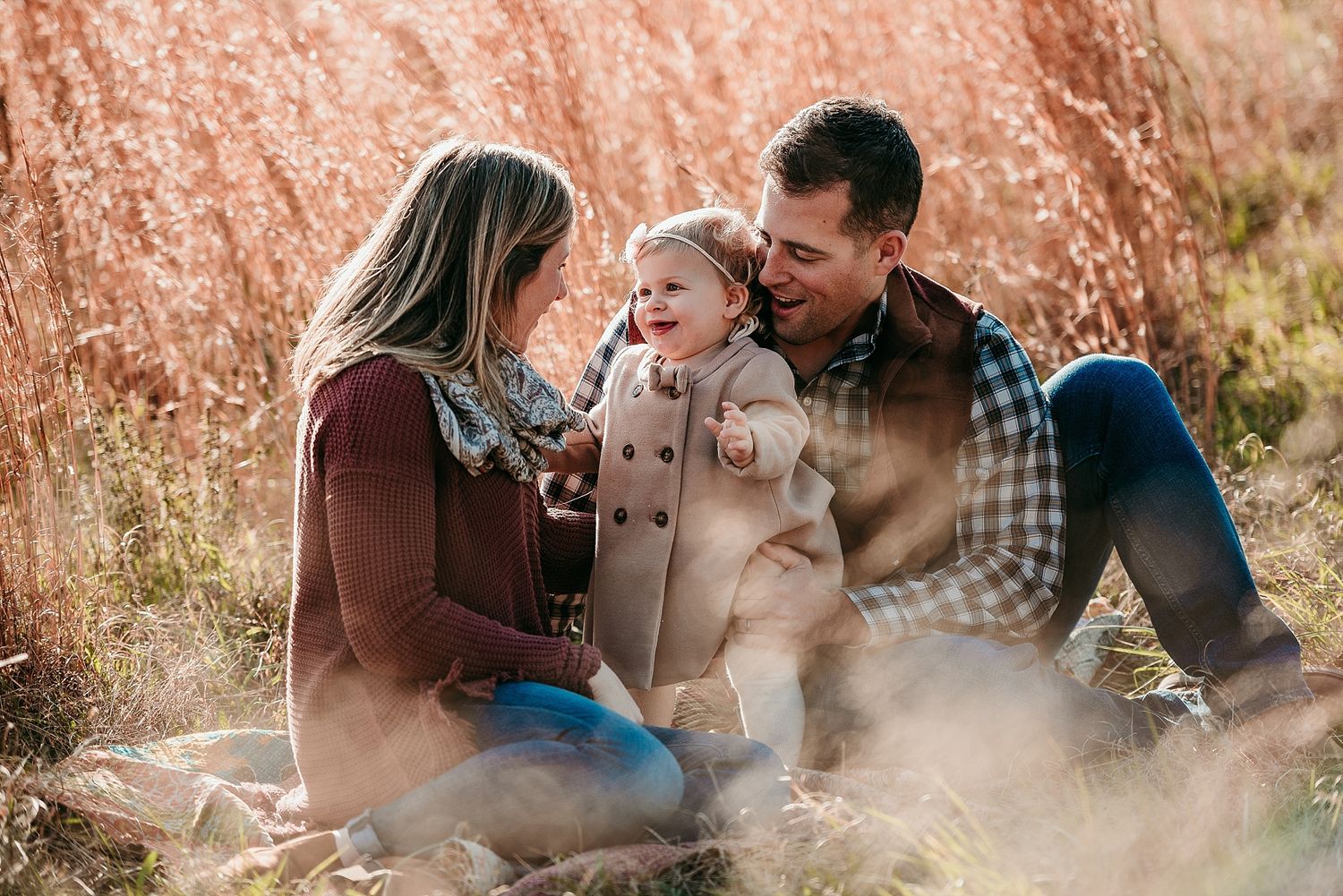 Family sharing tender moment together in autumn field.