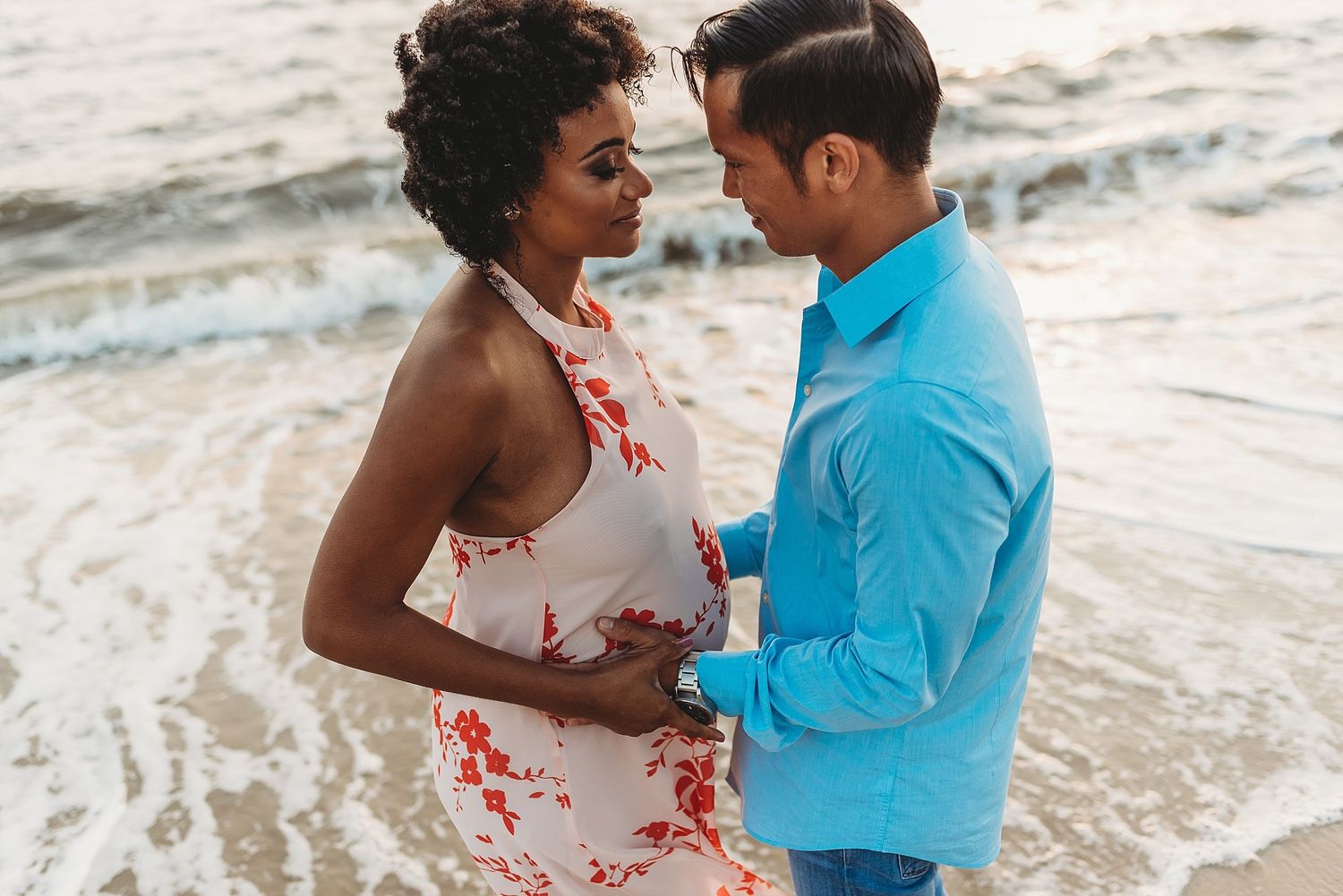 Intimate beachside portrait of couple in casual attire gazing at each other.