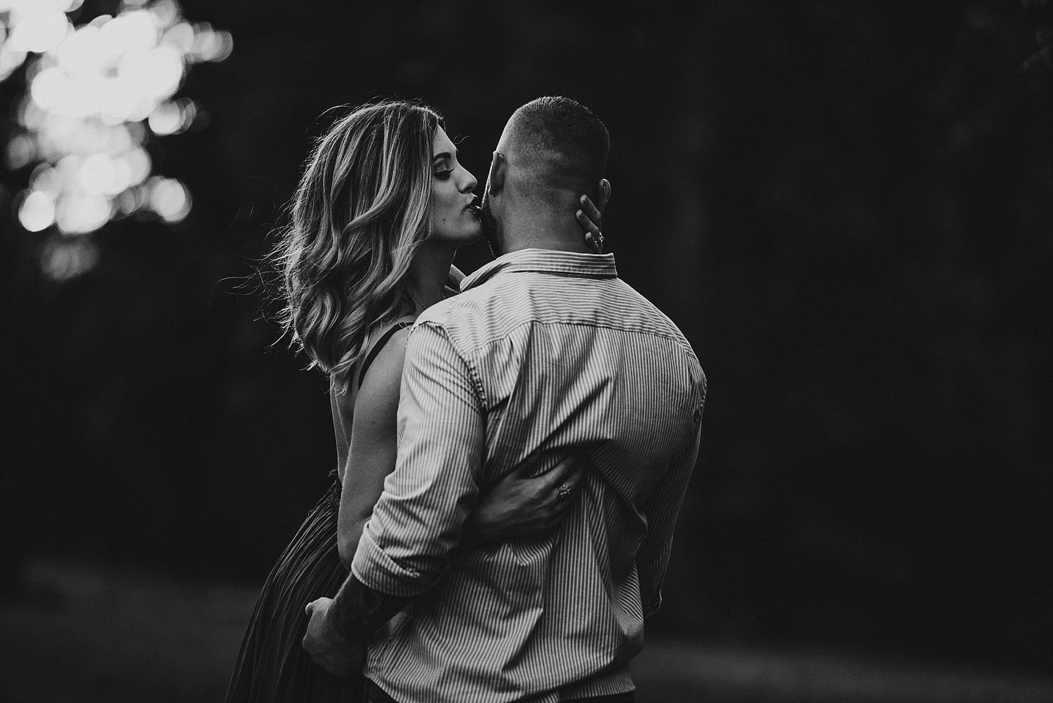 Intimate black and white portrait of couple with dramatic lighting.