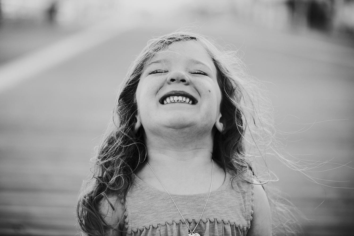 A joyful candid black and white portrait showing pure happiness and laughter.
