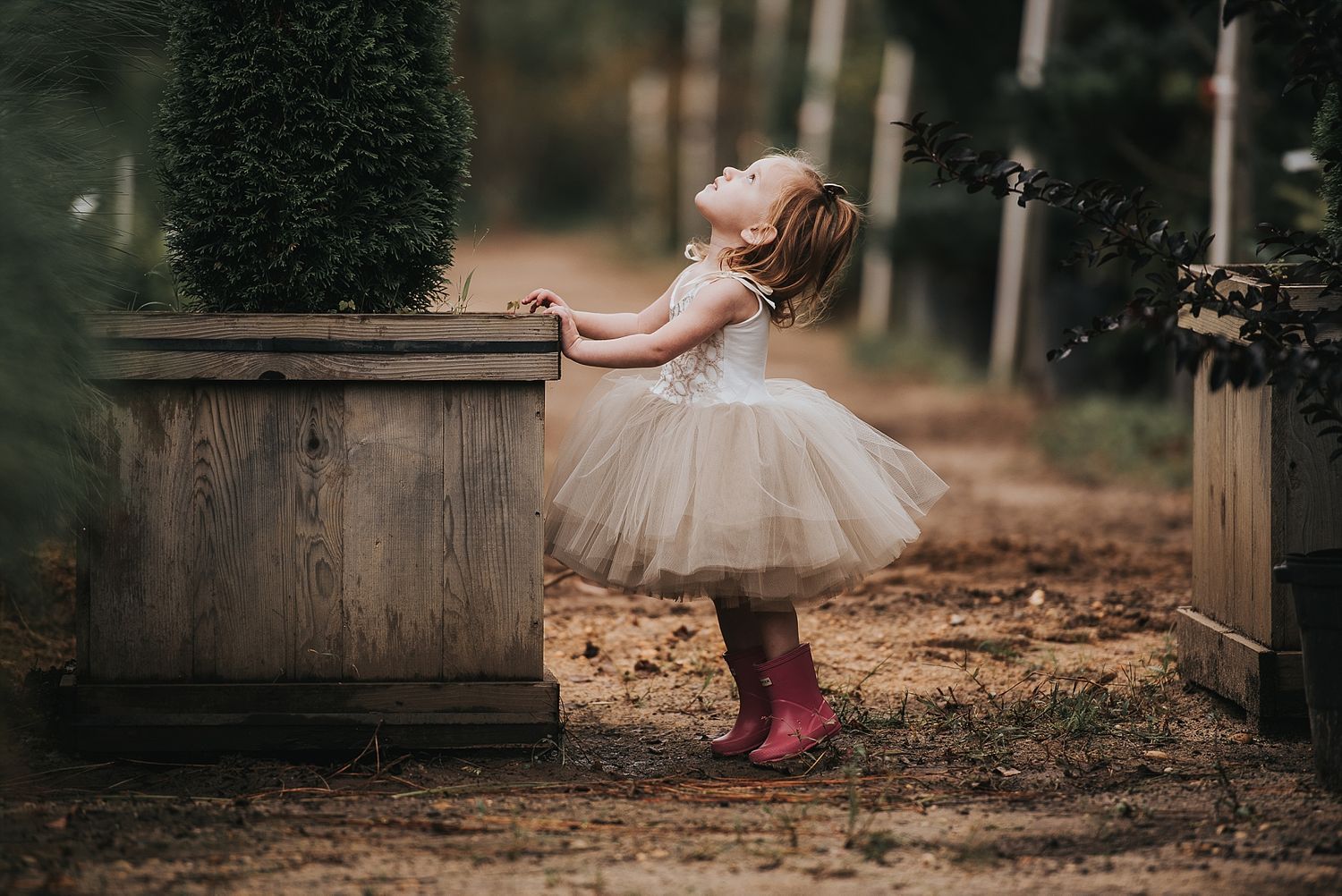 A dreamy photo of someone in a tulle dress and pink boots twirling outdoors.