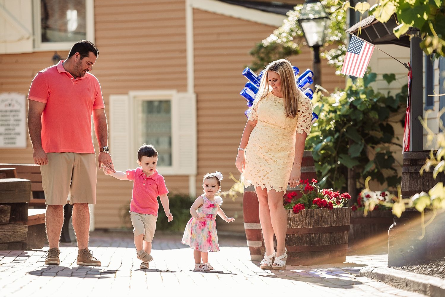 Group walking together on a sidewalk near houses with American flags.