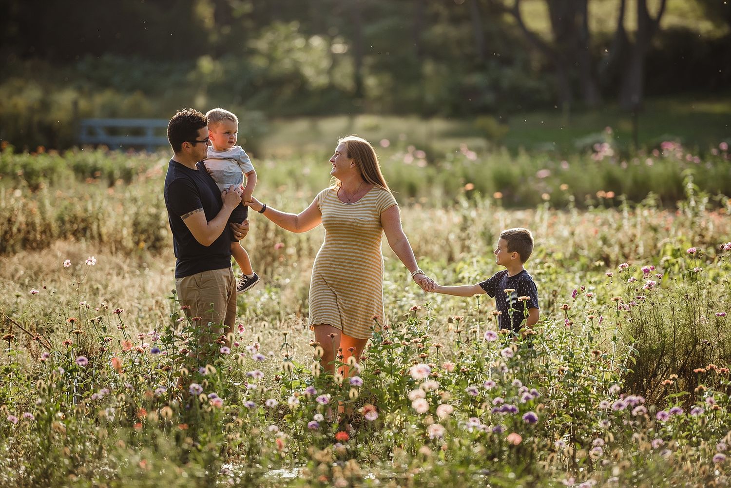 Group walking through tall wildflowers in golden evening light.