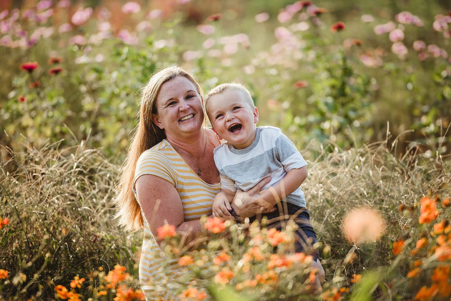 A joyful moment captured in a wildflower meadow with orange and pink blooms on a warm summer day.