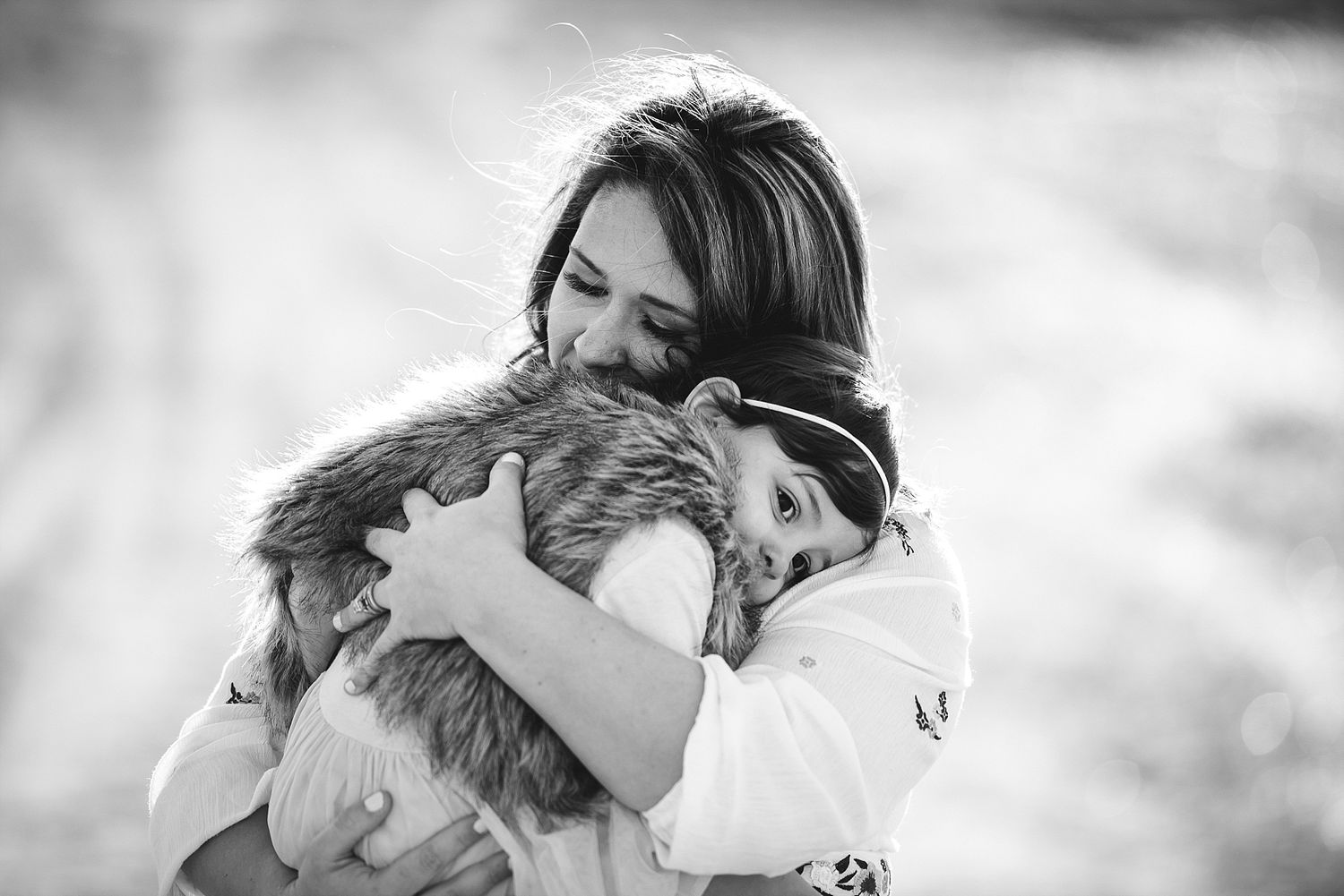 Tender black and white moment of affection with a fluffy pet in natural lighting.