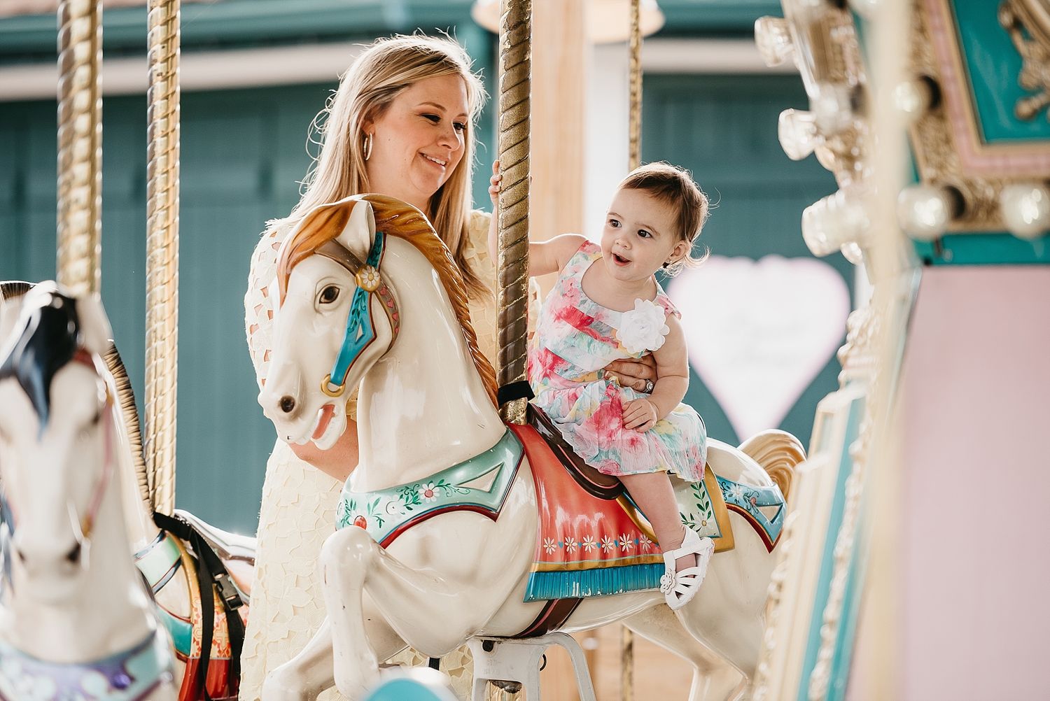 A joyful carousel ride featuring decorative white horses at an amusement park.
