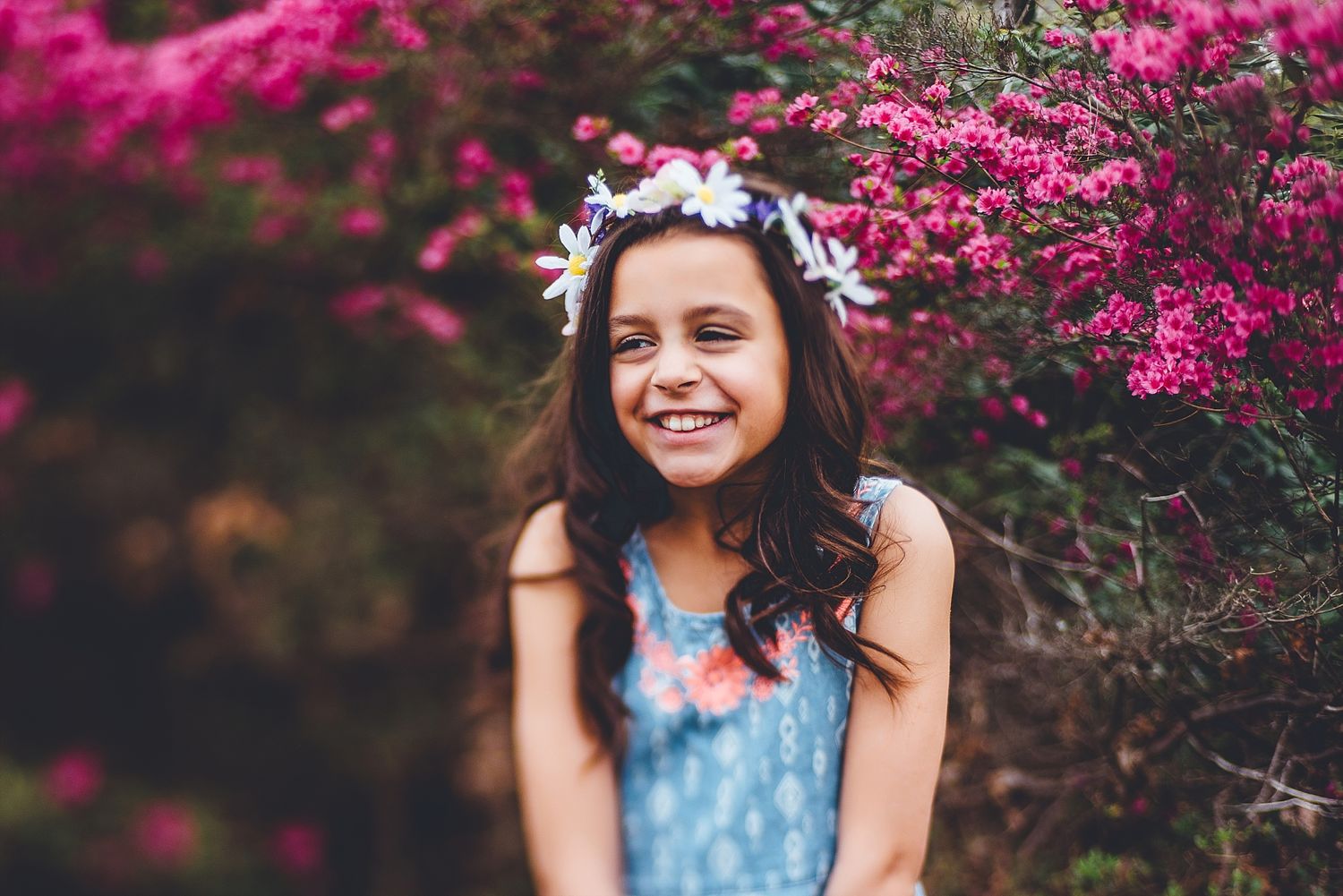 Spring portrait among vibrant pink bougainvillea flowers with a flower crown.