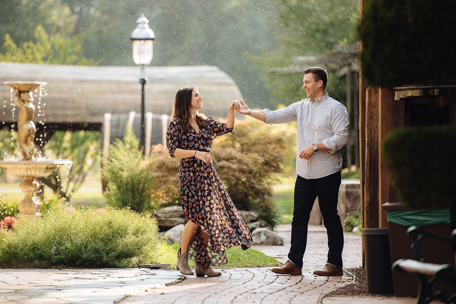A couple dances together on a stone patio during golden hour.