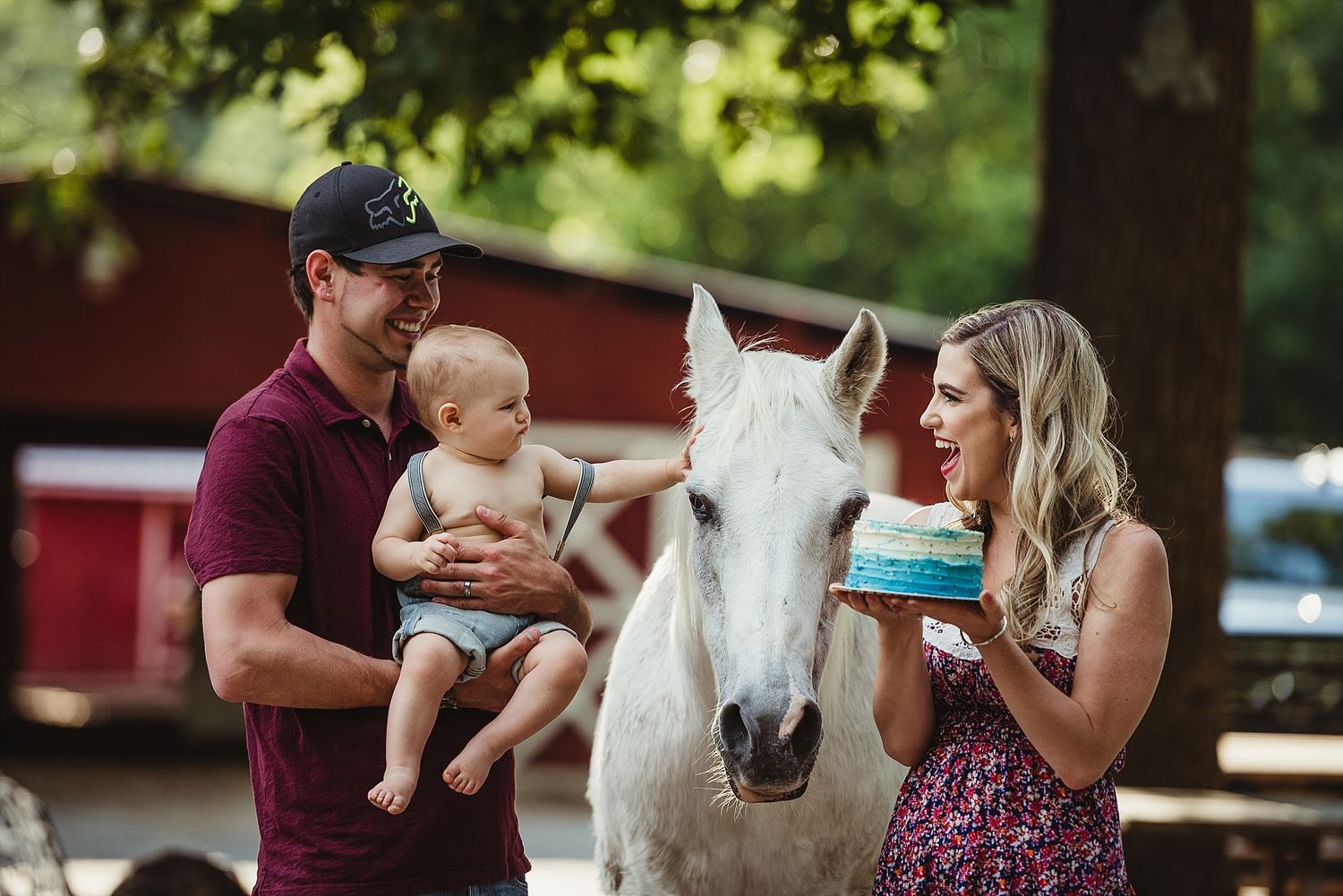 A casual family moment with a white horse at a rustic barn setting.