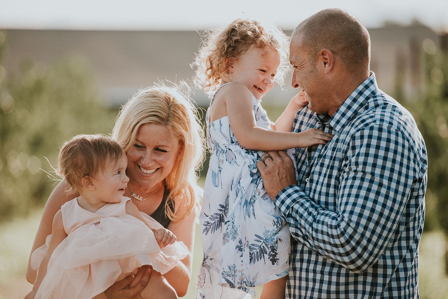 Family sharing joyful moments together outdoors in warm sunlight.