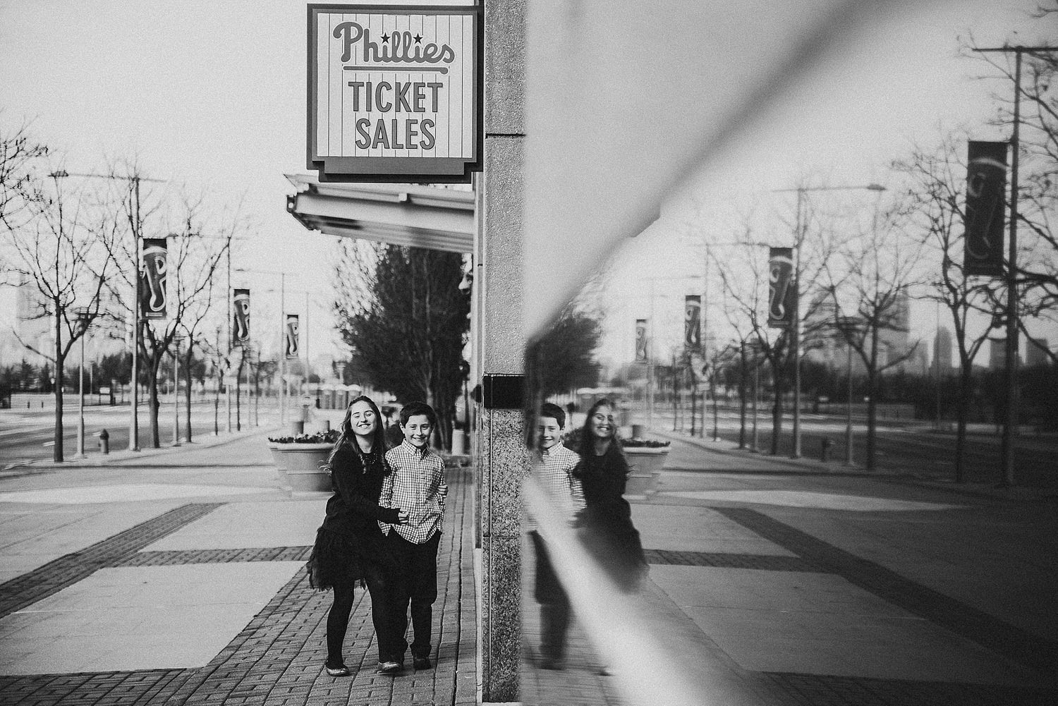 Black and white photo of people by Phillies ticket sales sign.