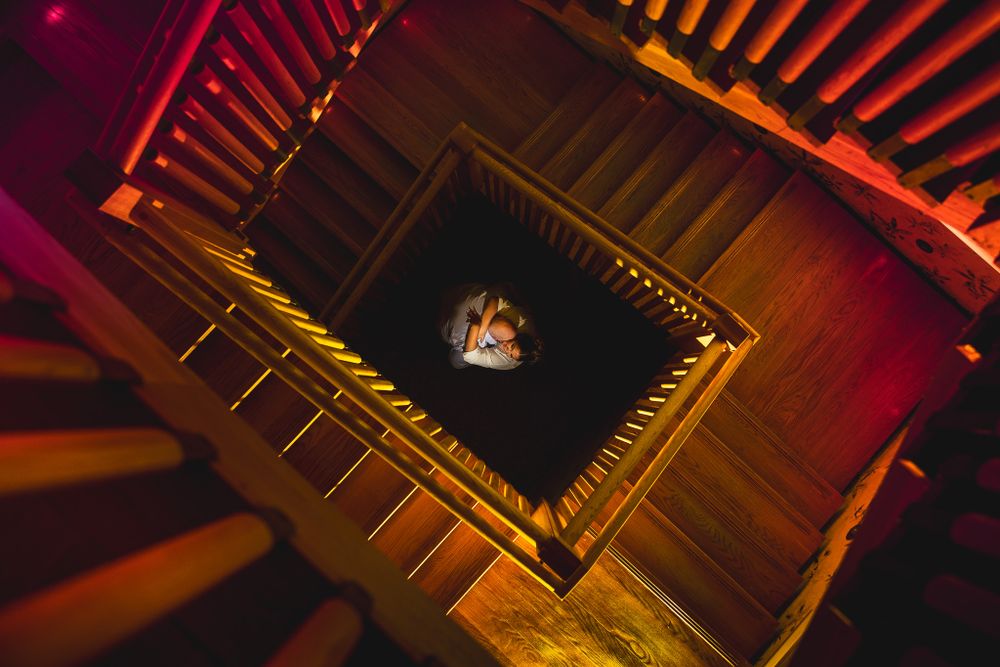engaged couple hugging surrounded by staircase at Avenue Le Club in long branch