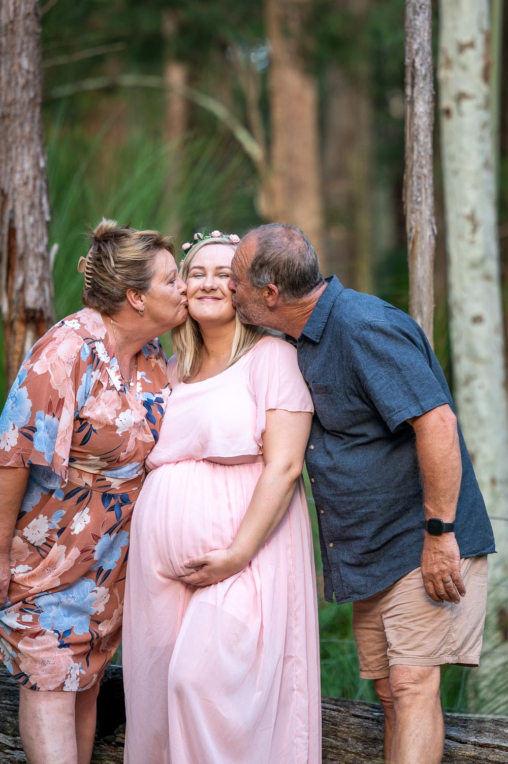 Mum to be receives a big kiss from her parents