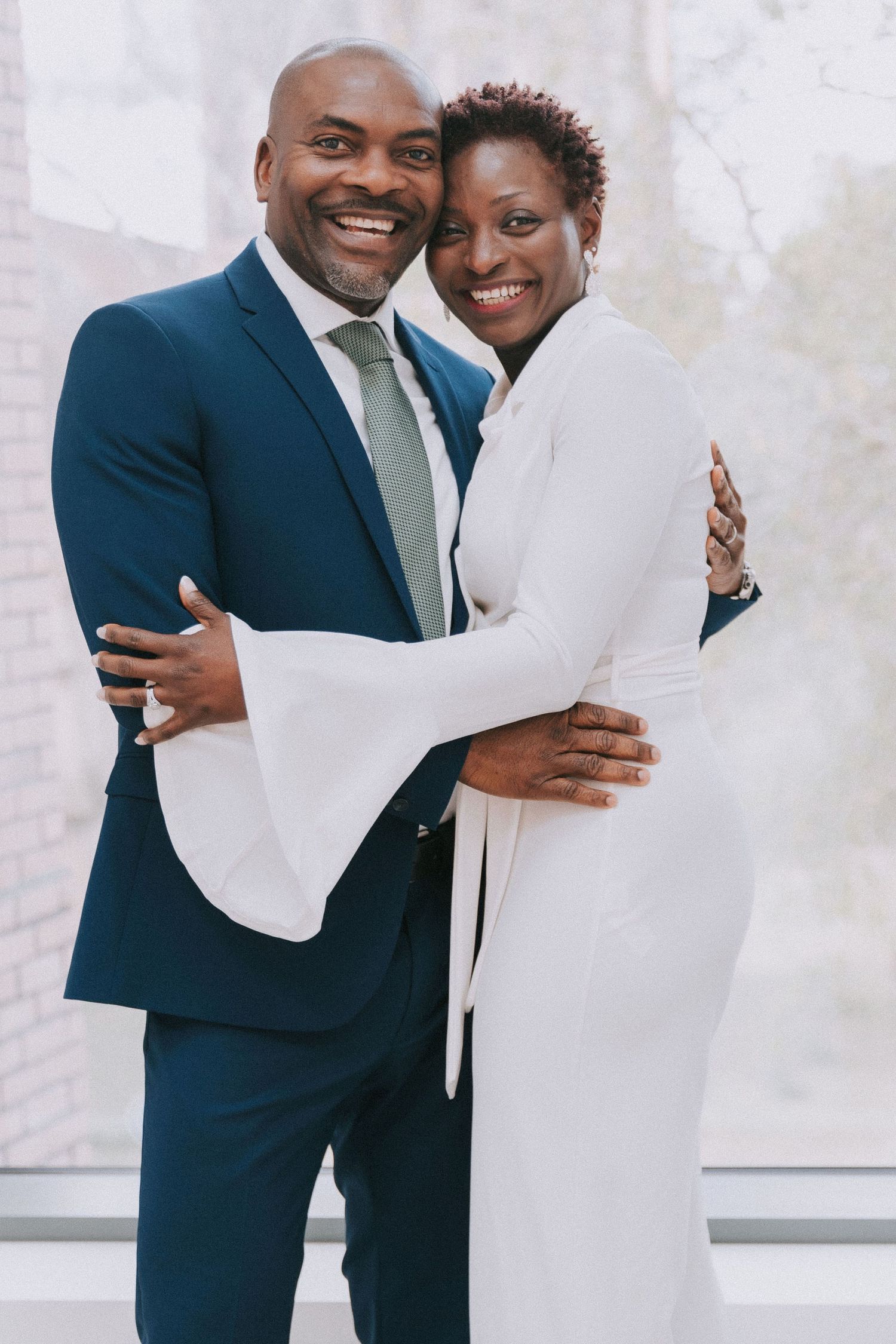 A couple in formal attire shares joyful moments during their courthouse ceremony.