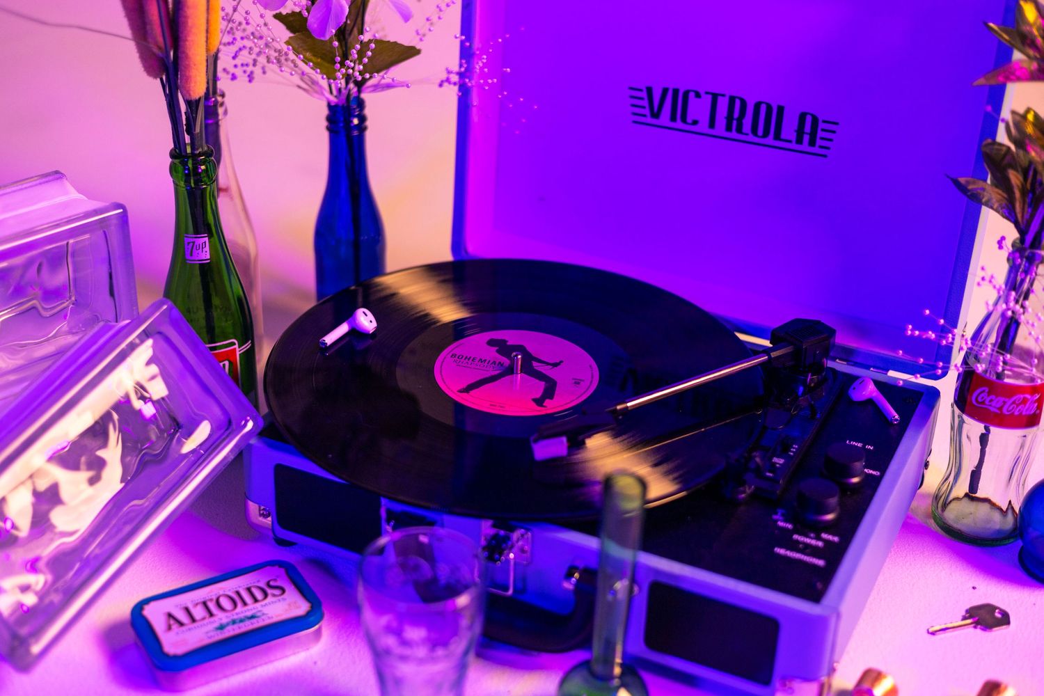 DJ setup with vinyl records illuminated by purple neon lighting.