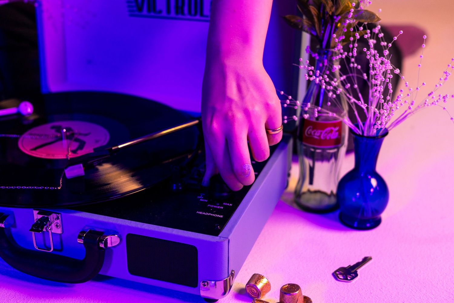 DJ equipment and records highlighted by colorful neon lighting.