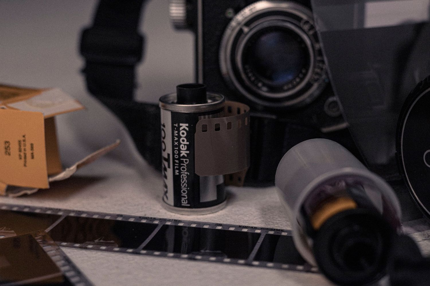 Close-up of vintage film rolls and negatives alongside camera equipment.