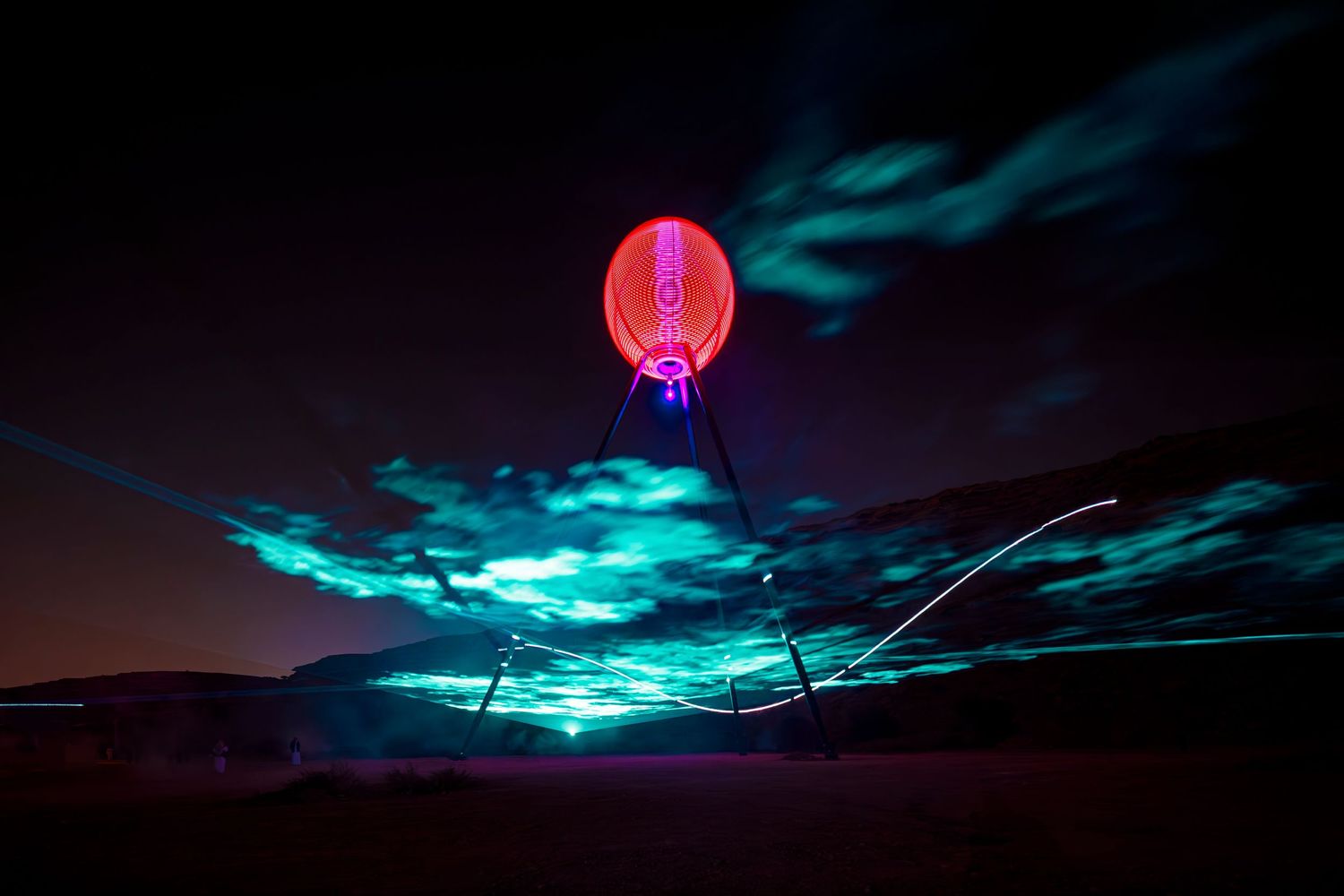 A glowing red orb floats beneath turquoise clouds in a nighttime desert landscape.