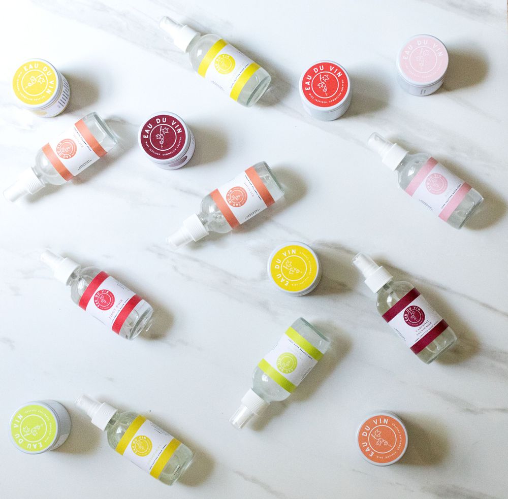 Collection of colorful skincare product containers arranged on white marble surface.