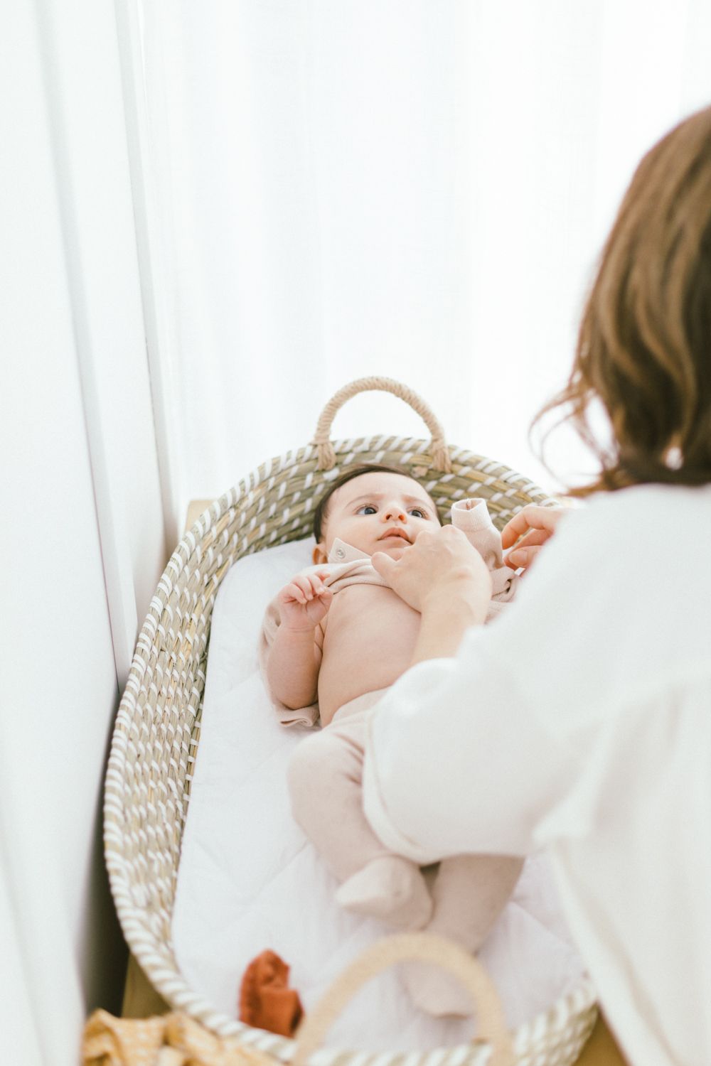 Cozy nursery moment with woven baby basket in natural light.
