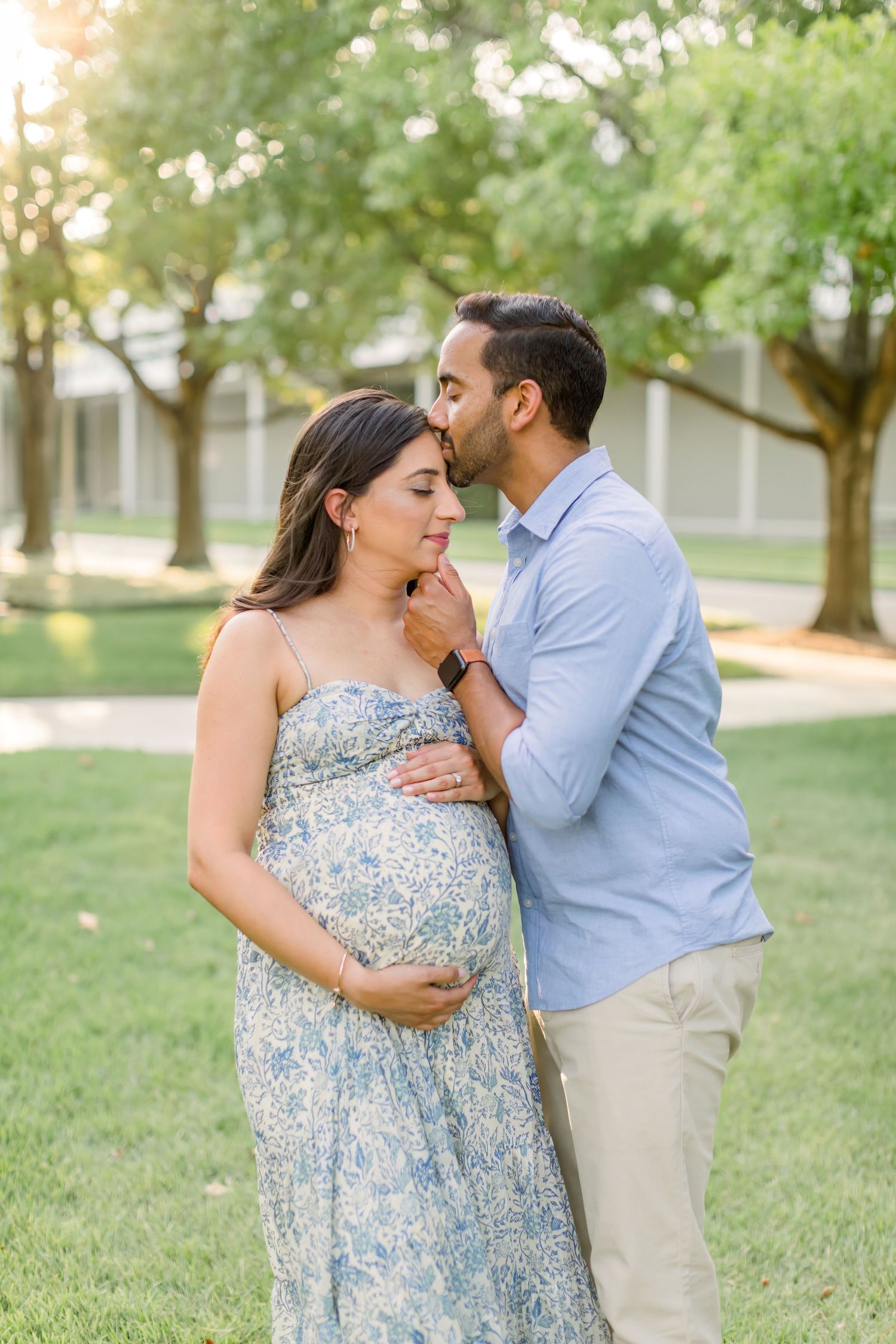 Intimate moment between couple during outdoor maternity photoshoot.