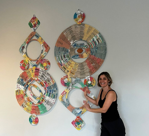 Large decorative wall art pieces made from metallic and colorful woven materials in circular patterns.