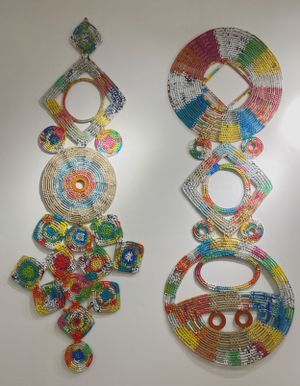 Two decorative beaded wall hangings with geometric and circular patterns in multicolored designs.