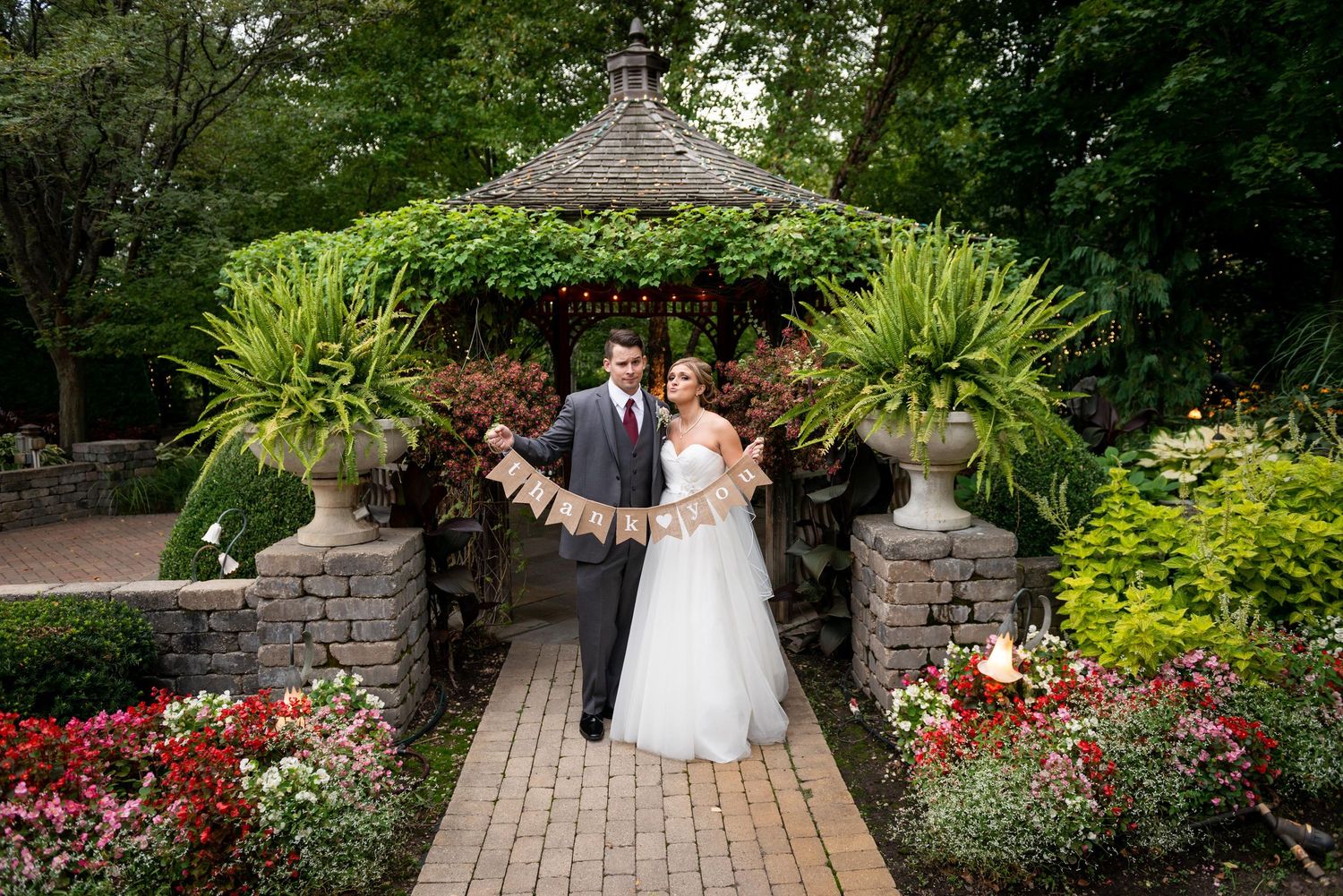 Beautiful garden wedding venue with stone pathway surrounded by colorful flowers and greenery.