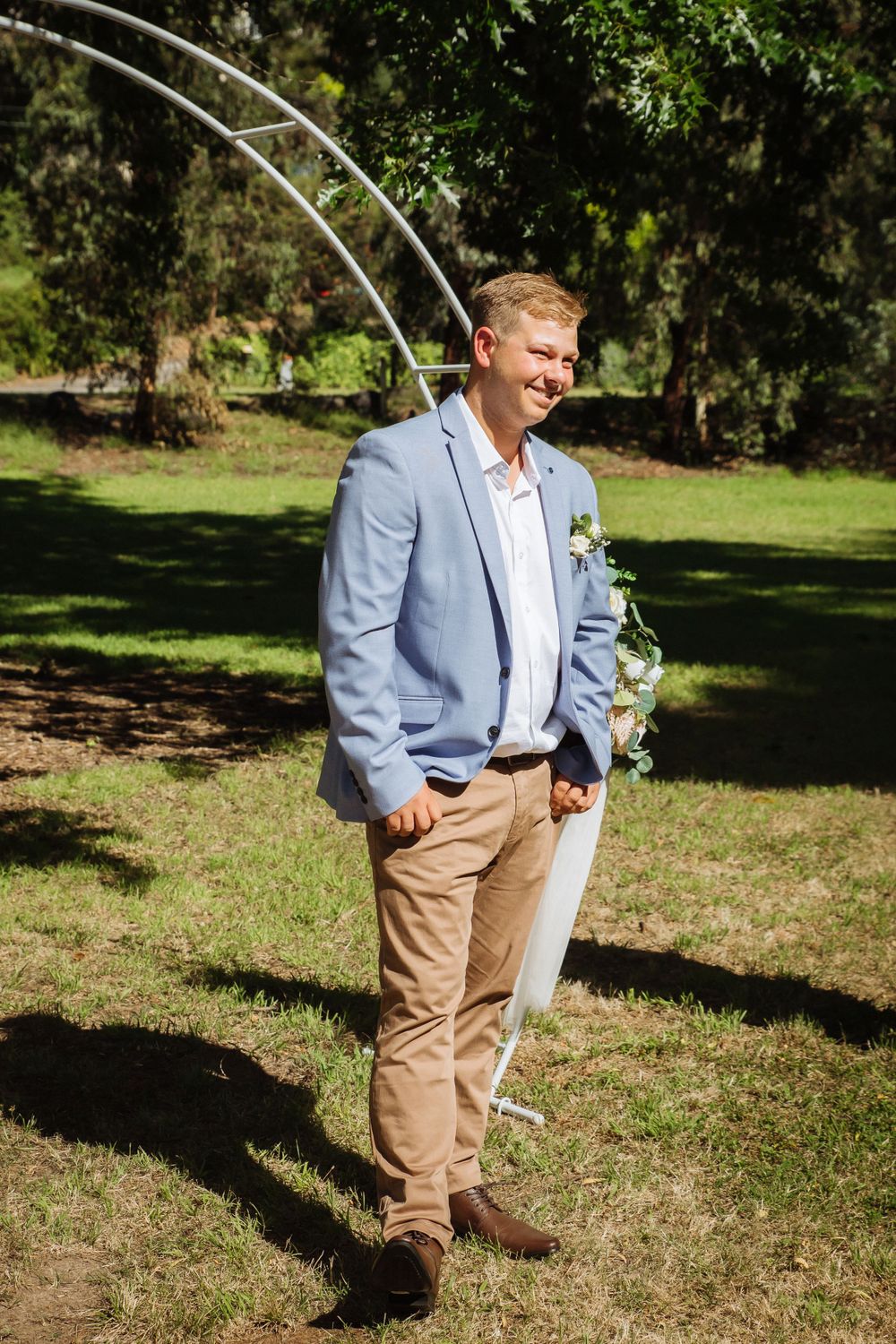 casually dressed blonde groom in grey jacket and chinos seeing bride for first time