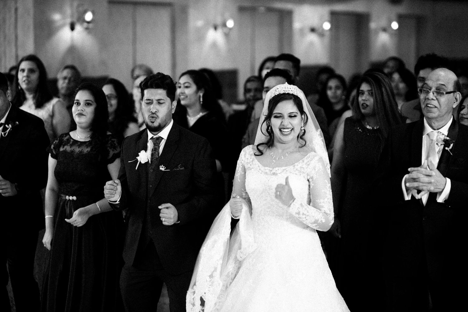 Black and white photo of wedding guests watching the celebration unfold.