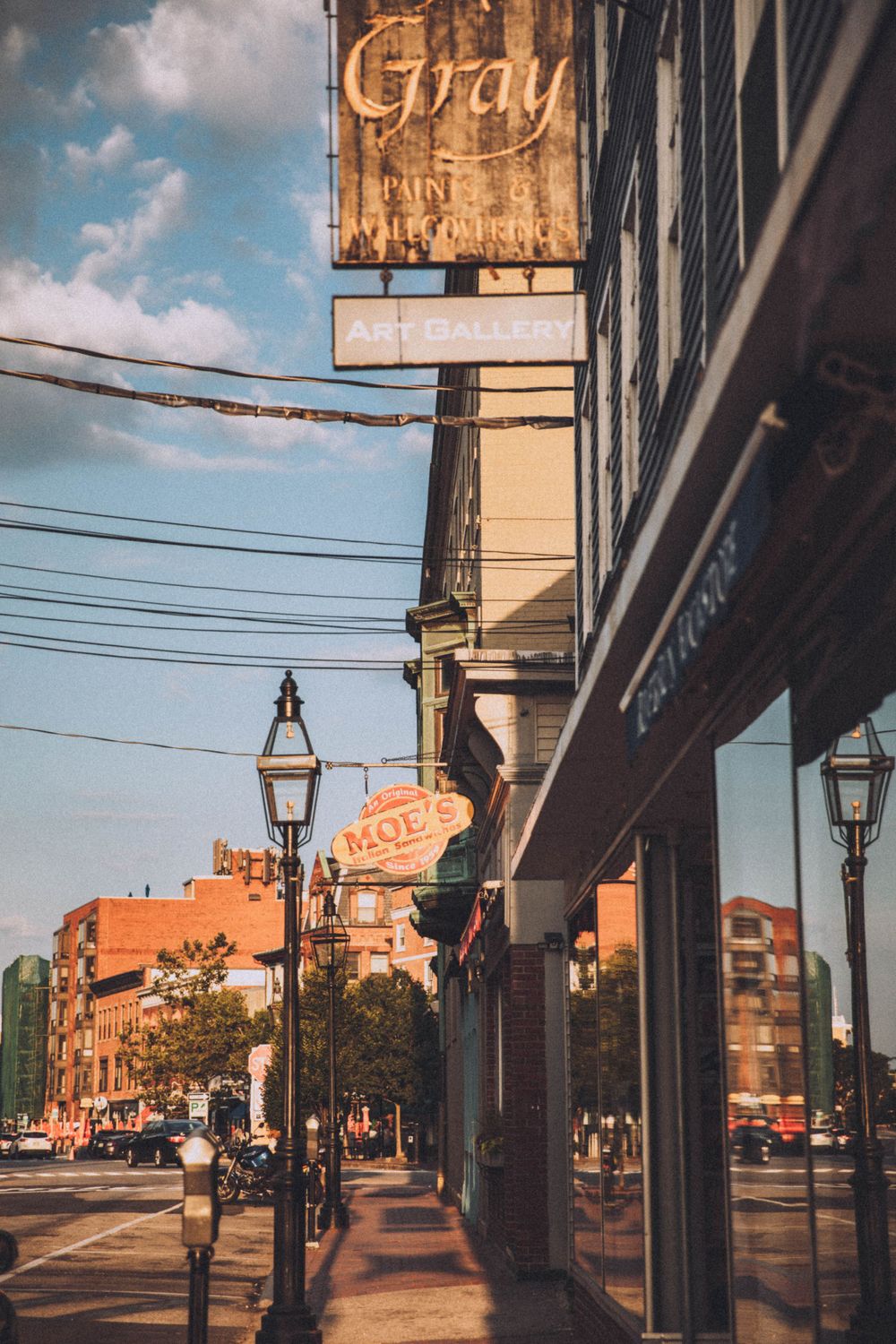 Urban street scene with vintage buildings and lampposts during golden hour.