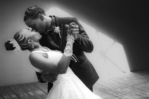 Black and white, bride and groom kissing as the groom dips the bride.