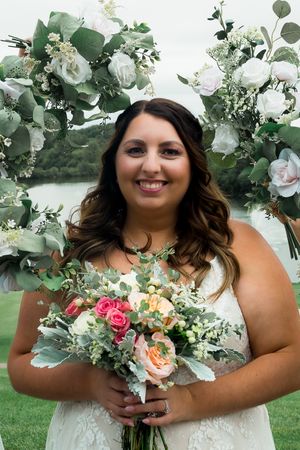 Bride facing camera with bouquets surrounding her