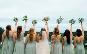 Bridal and bridesmaids facing away and raising their bouquets
