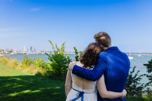 bride and groom embrace after first look facing lake michigan and downtown milwaukee skyline