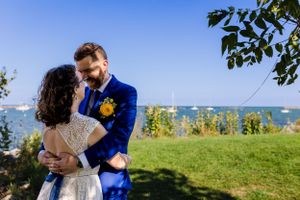 bride and groom embracing in front of lake michigan