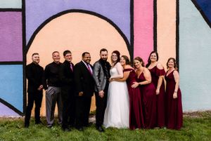 bride and groom with bridal party in front of kenosha murall