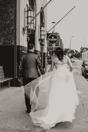 bride and groom black and white walking down street in downtown kenosha