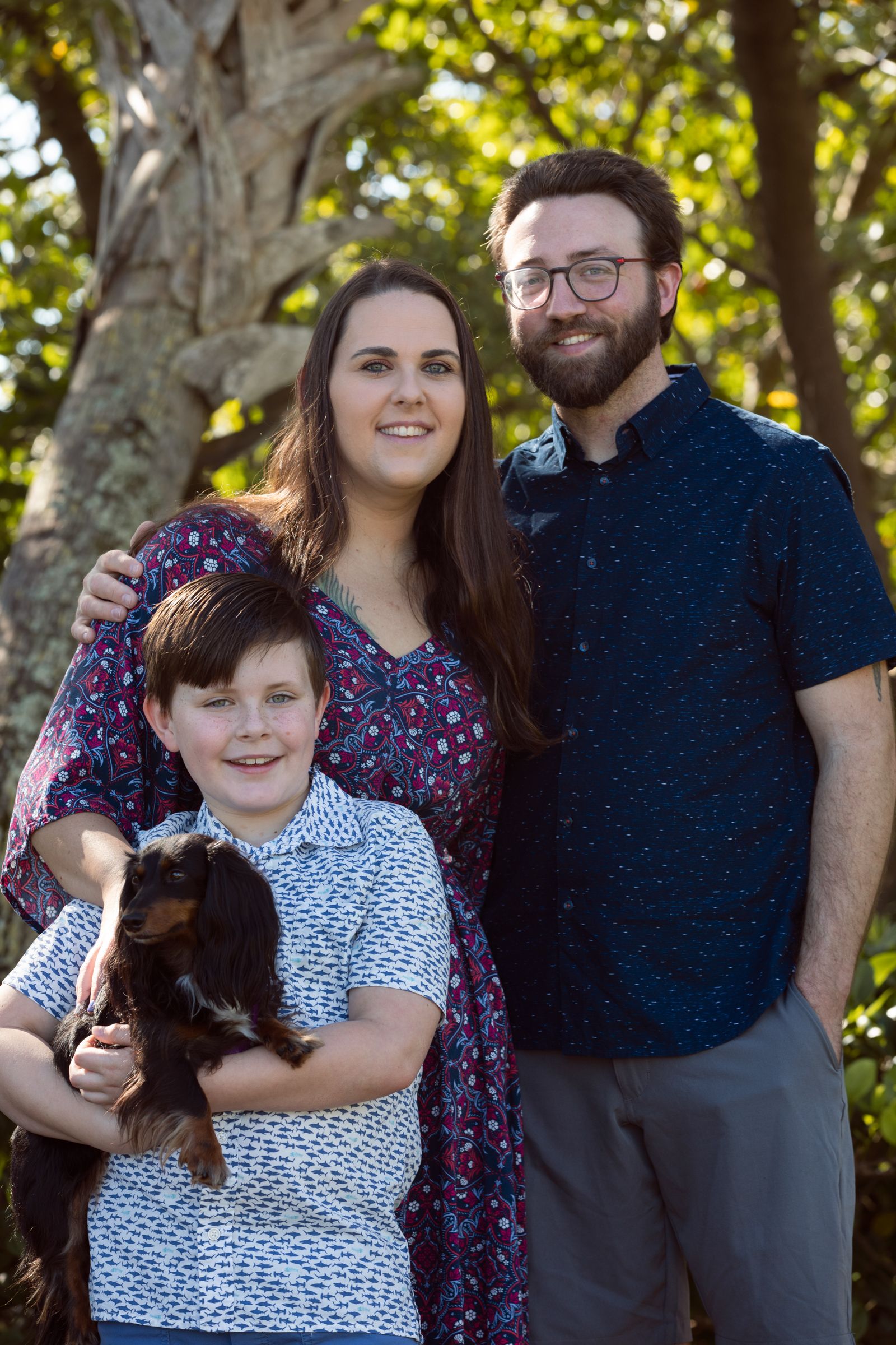Family portrait outdoors with a small dog