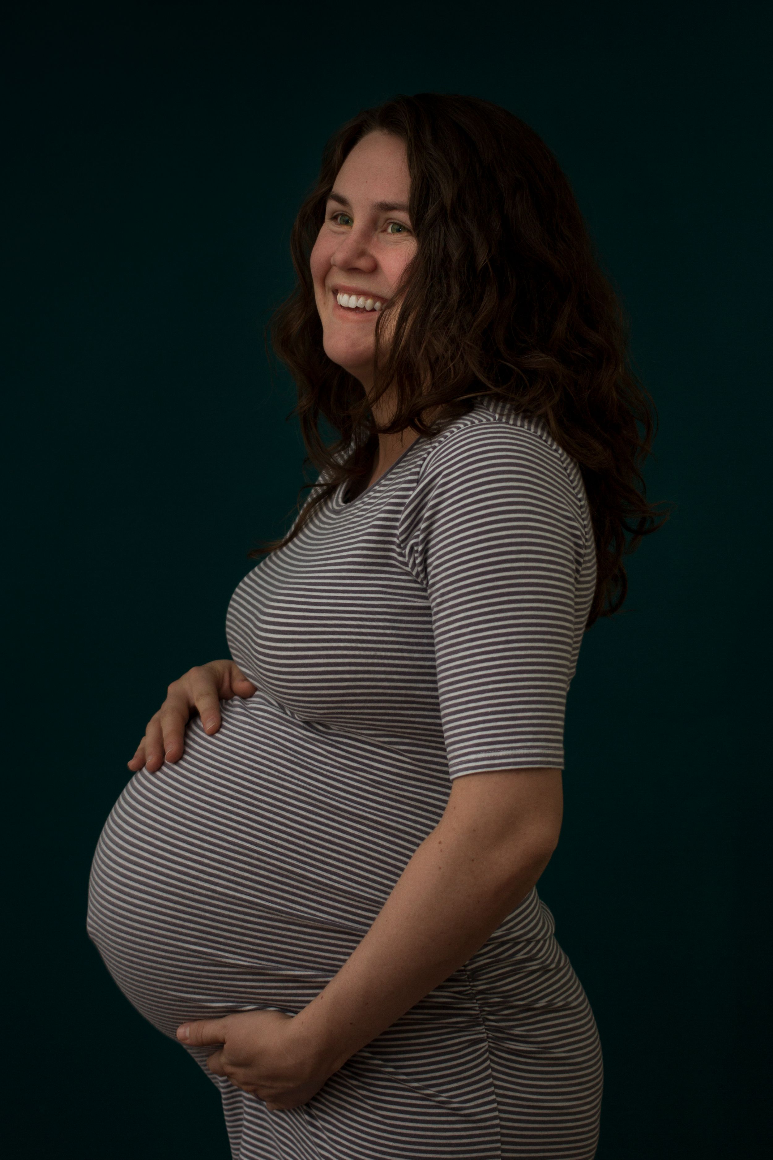 Maternity portrait on a dark green background