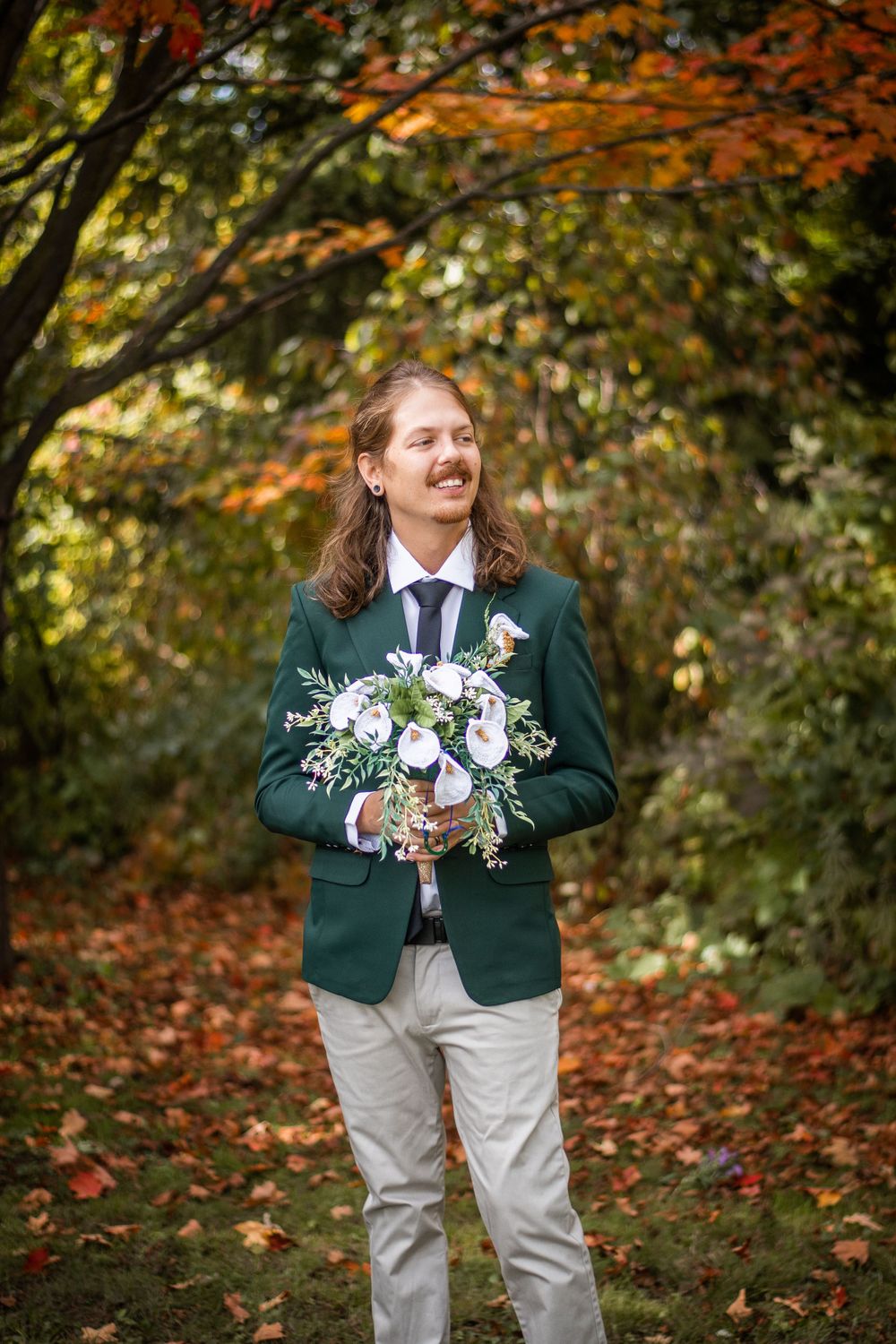 groom holding bridal bouquet candid outdoor photo fall autumn wedding
