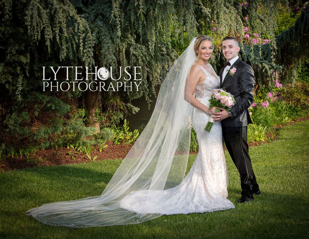 a bride and groom standing in front of lush green grass, in the style of softbox lighting, larry elmore, luxurious