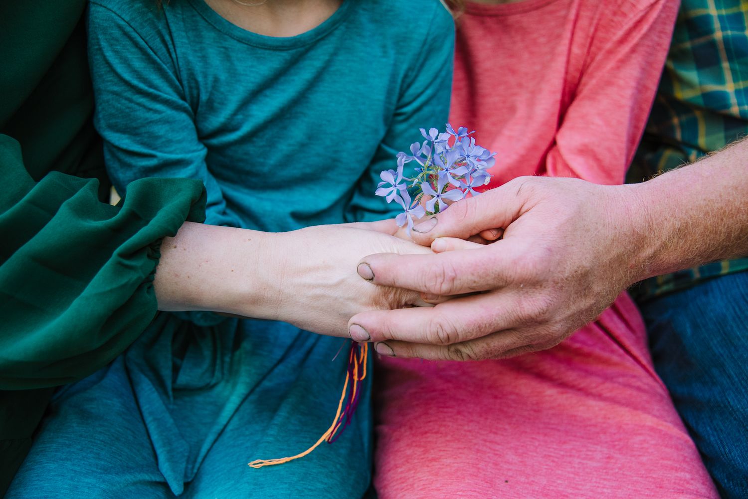 Family of four holding wildflowers