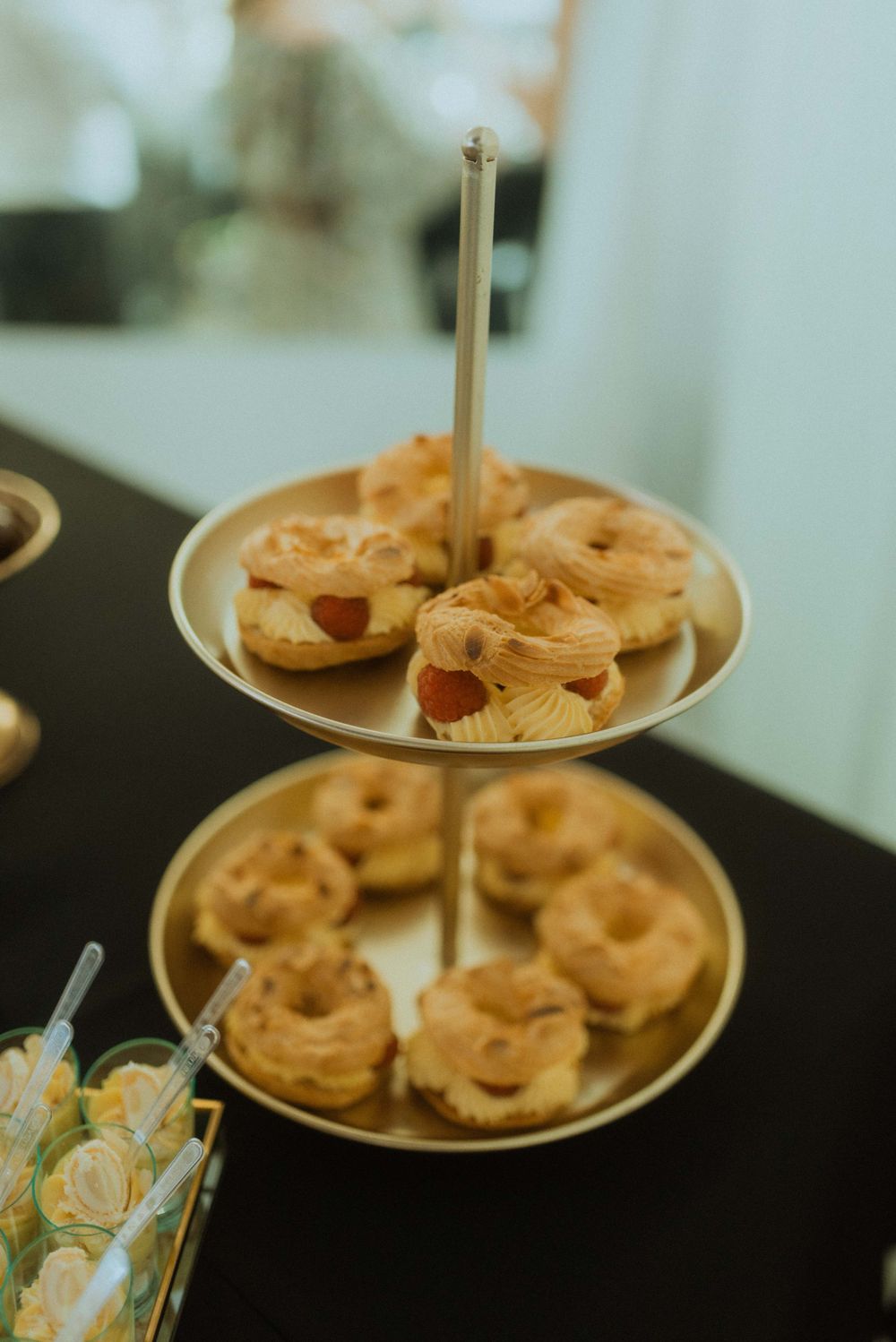Two-tiered serving platter with decorated donuts on elegant display.