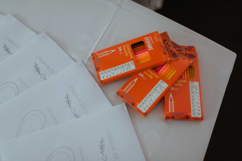 Orange packets scattered on white surface in dim lighting.