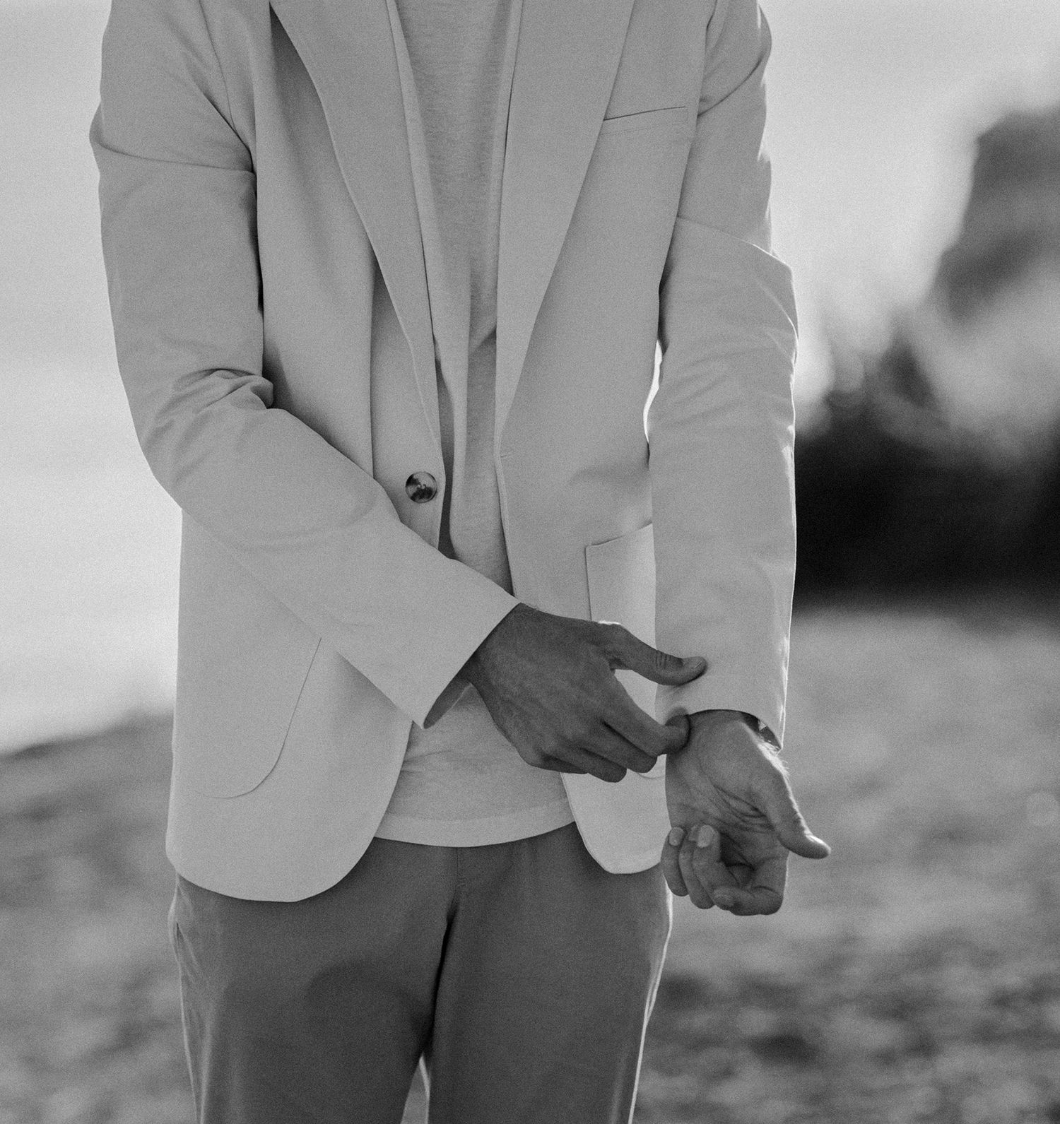 Groom portrait putting on tan and white suit