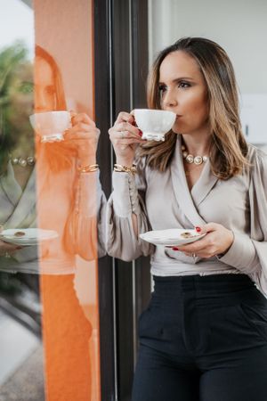 Elegant tea drinking session by window in professional office environment.