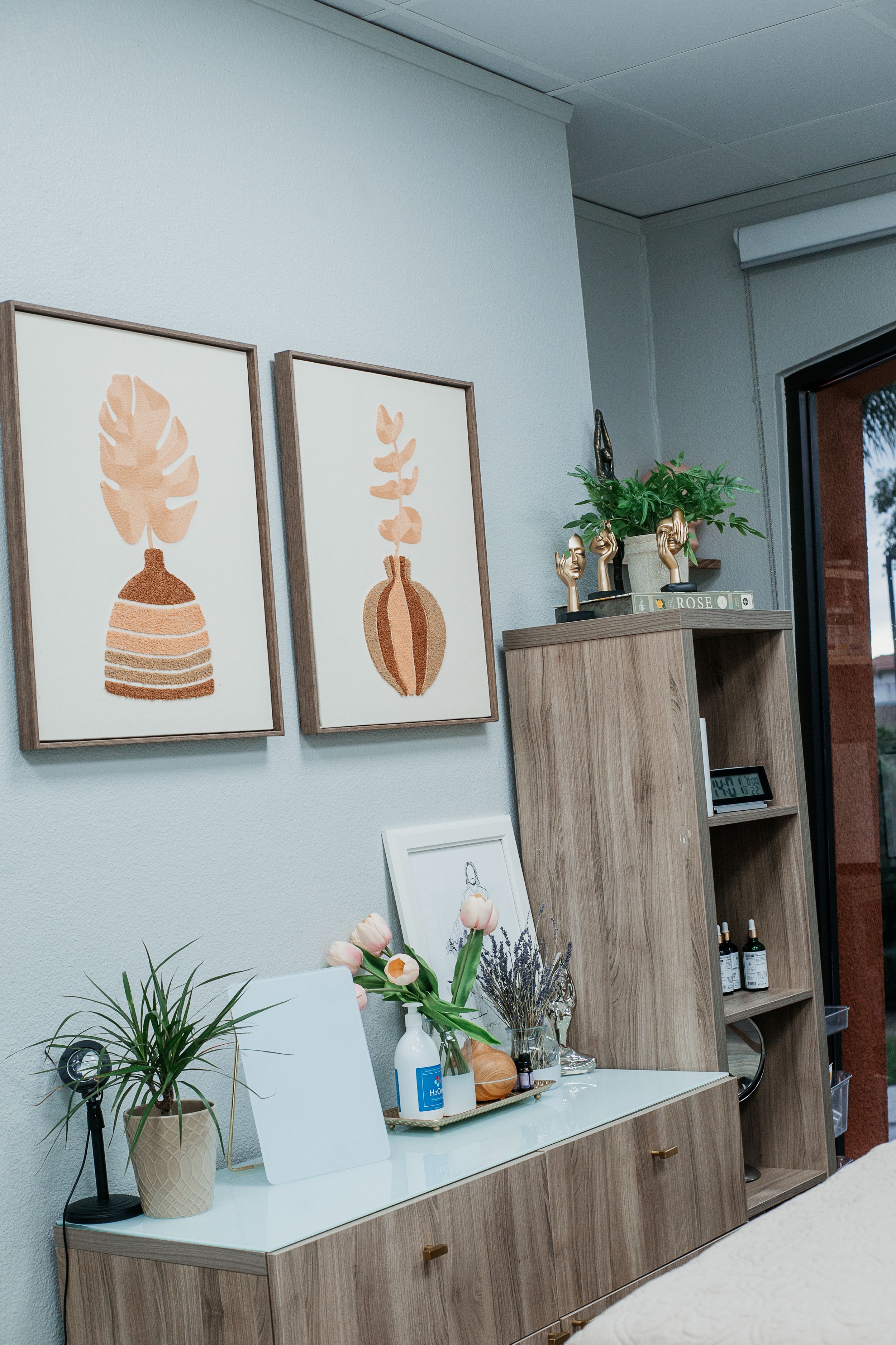 Modern office wall decorated with minimalist botanical art prints in wooden frames.