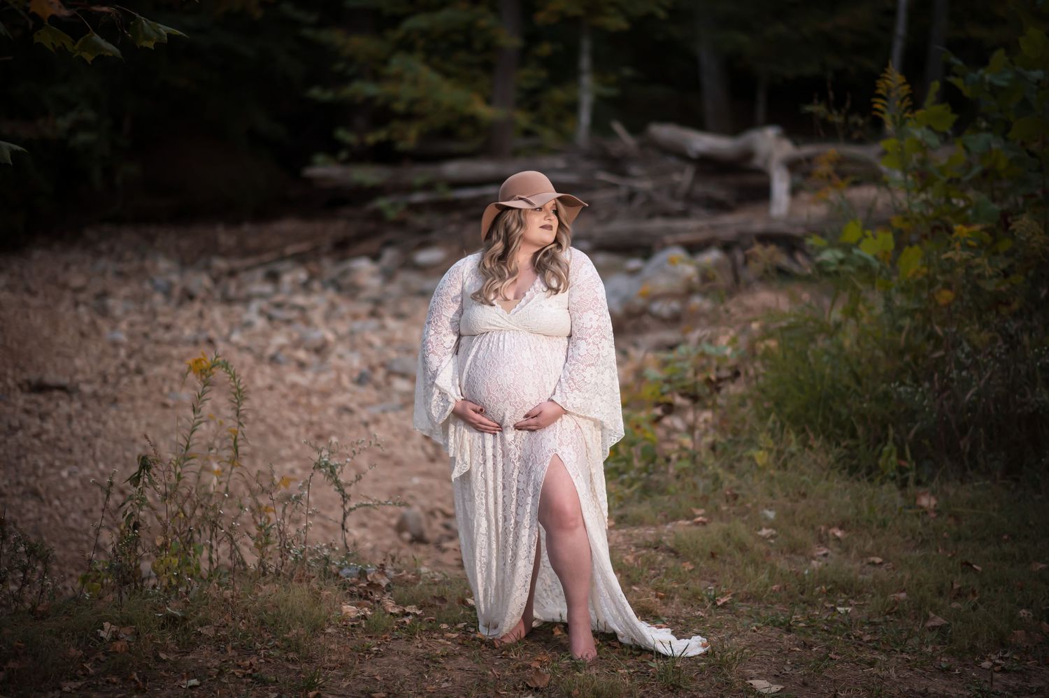 Elegant maternity portraits in a natural outdoor setting during golden hour.