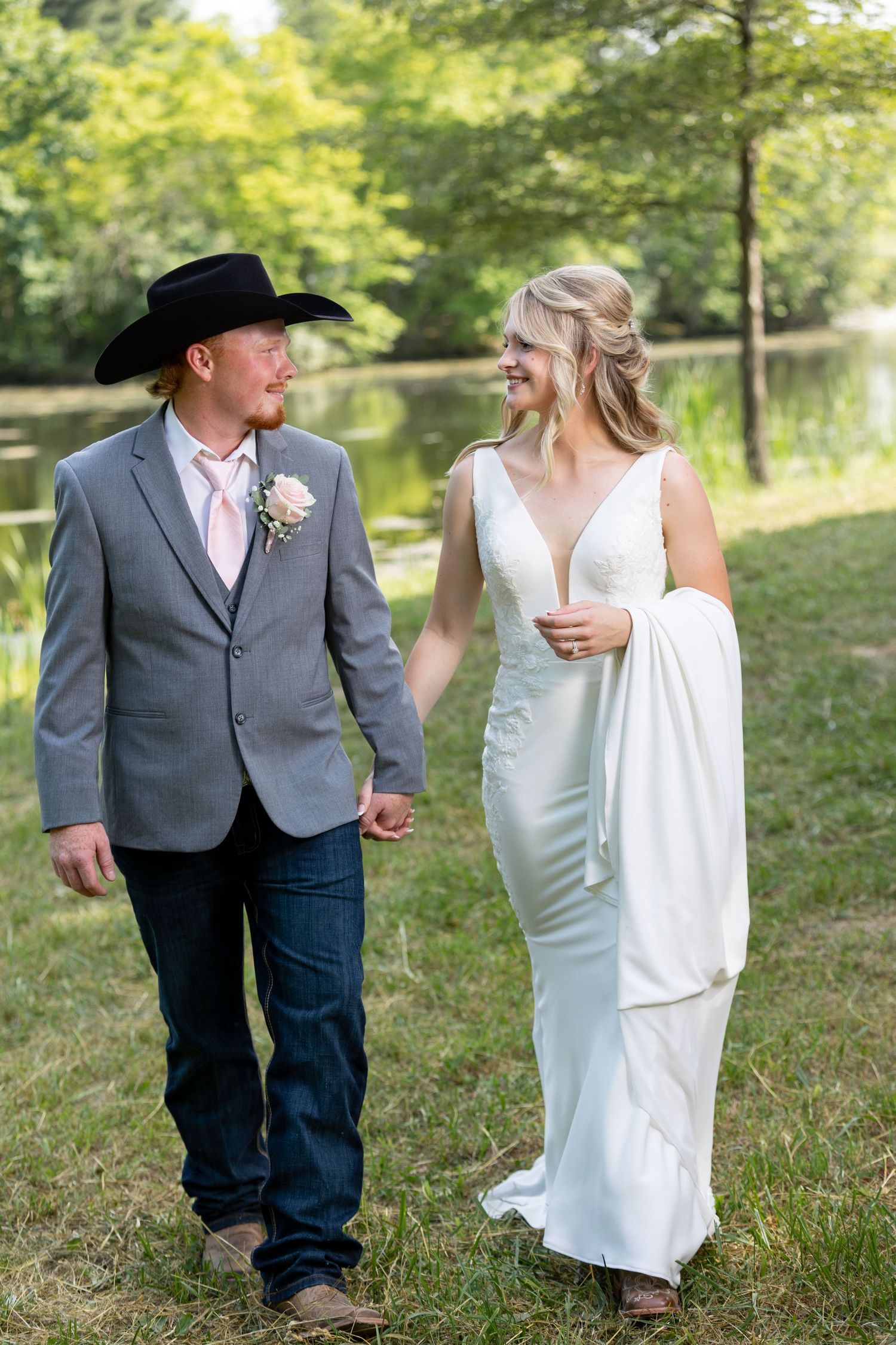 Newly married cowboy couple stroll hand-in-hand just after their wedding ceremony in Effingham, Illinois